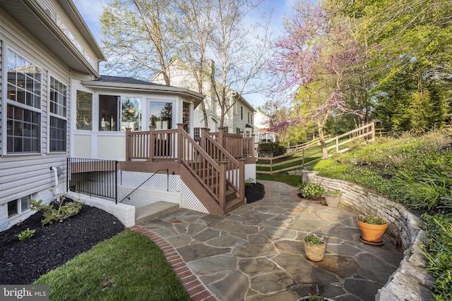 wooden terrace with fence and a patio area