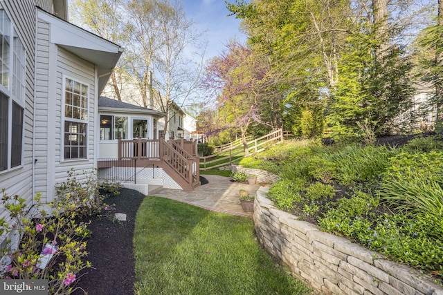 view of yard featuring a sunroom, a patio area, and fence