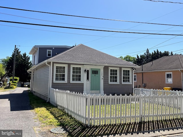 bungalow featuring roof with shingles and a fenced front yard