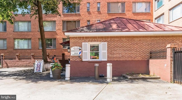 1021 Arlington Blvd Unit 928, Arlington, VA 22209 - exterior space featuring brick siding, a standing seam roof, fence, and metal roof