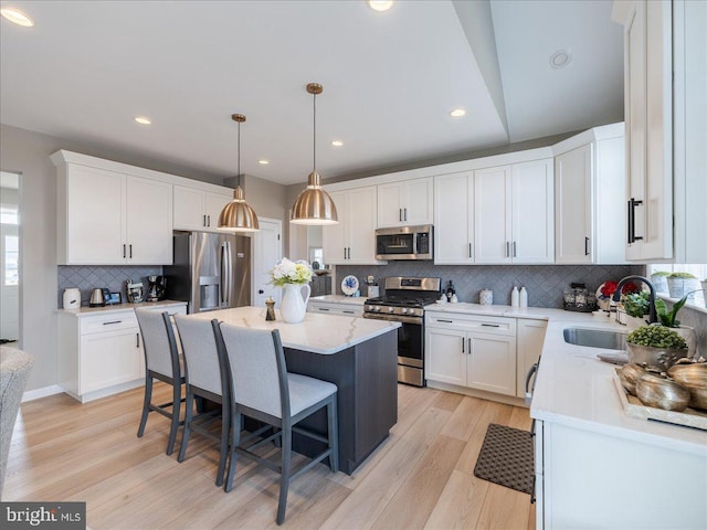 190 Petrelia Dr, Honey Brook, PA 19344 - kitchen featuring a kitchen bar, a center island, white cabinetry, a sink, and appliances with stainless steel finishes
