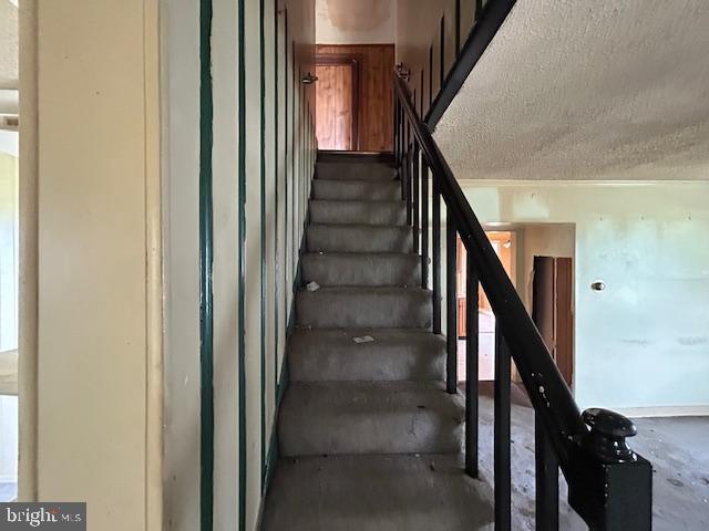 3129 Sollers Point Rd, Baltimore, MD 21222 - staircase with a textured ceiling