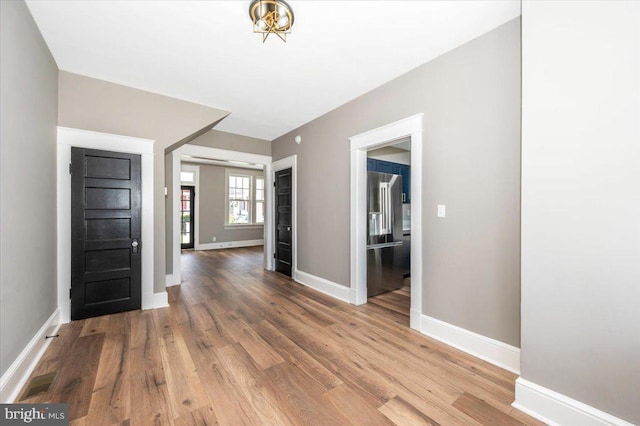 foyer entrance with baseboards and wood finished floors