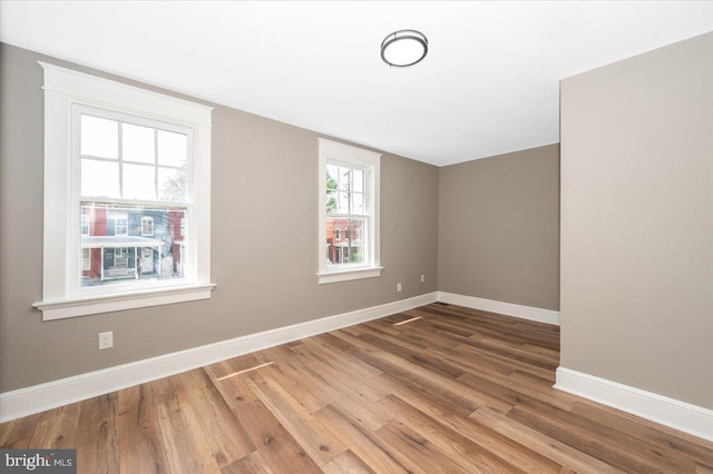 bonus room with baseboards and wood finished floors