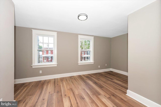 empty room with baseboards and wood finished floors