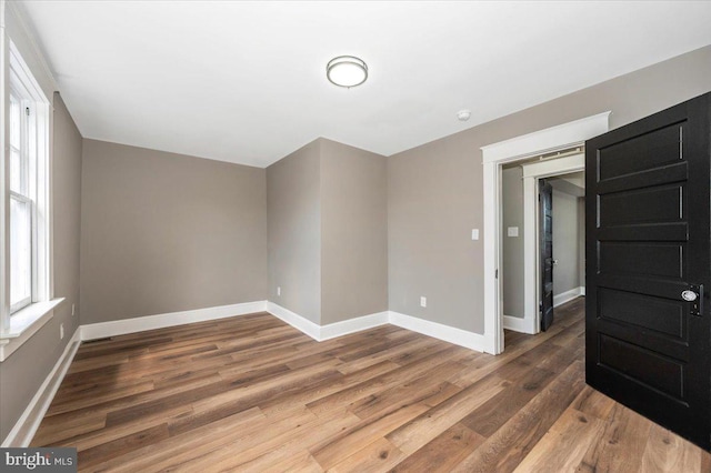 empty room with baseboards and wood finished floors