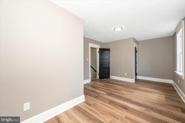unfurnished room featuring baseboards and light wood-style flooring