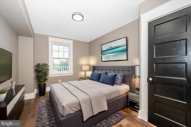 bedroom featuring baseboards and wood finished floors