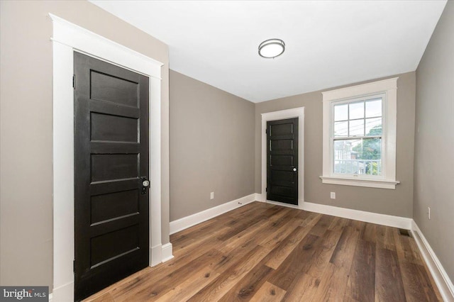 foyer entrance with baseboards and dark wood finished floors