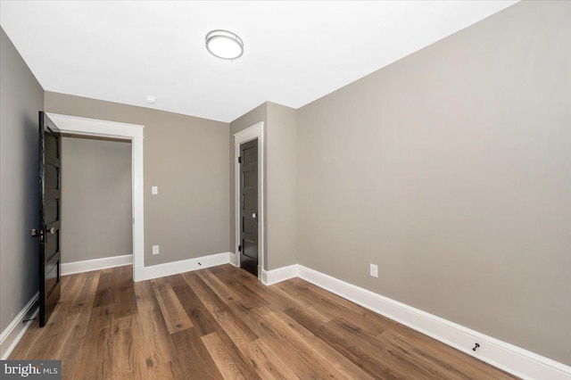 unfurnished bedroom with baseboards and wood finished floors