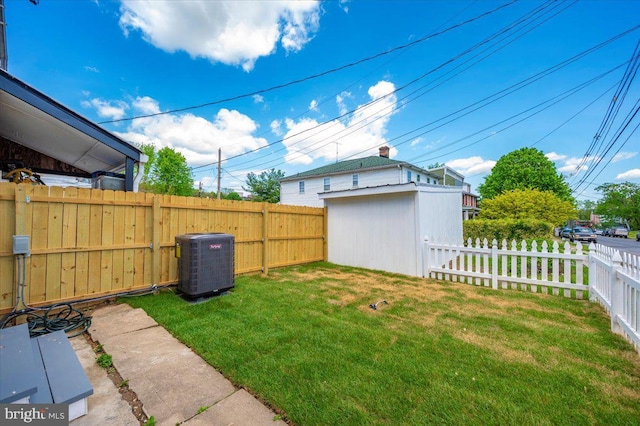 view of yard featuring a storage unit, a fenced backyard, an outdoor structure, and cooling unit