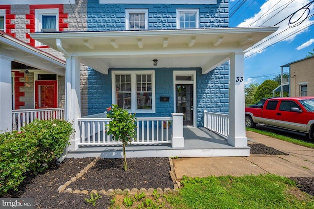 doorway to property featuring covered porch and stone siding