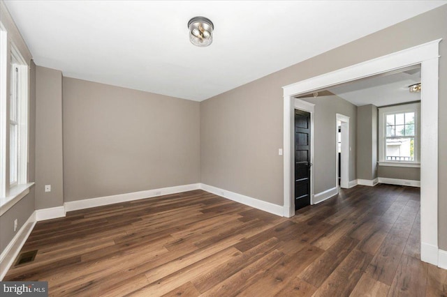 empty room with baseboards, wood finished floors, and visible vents
