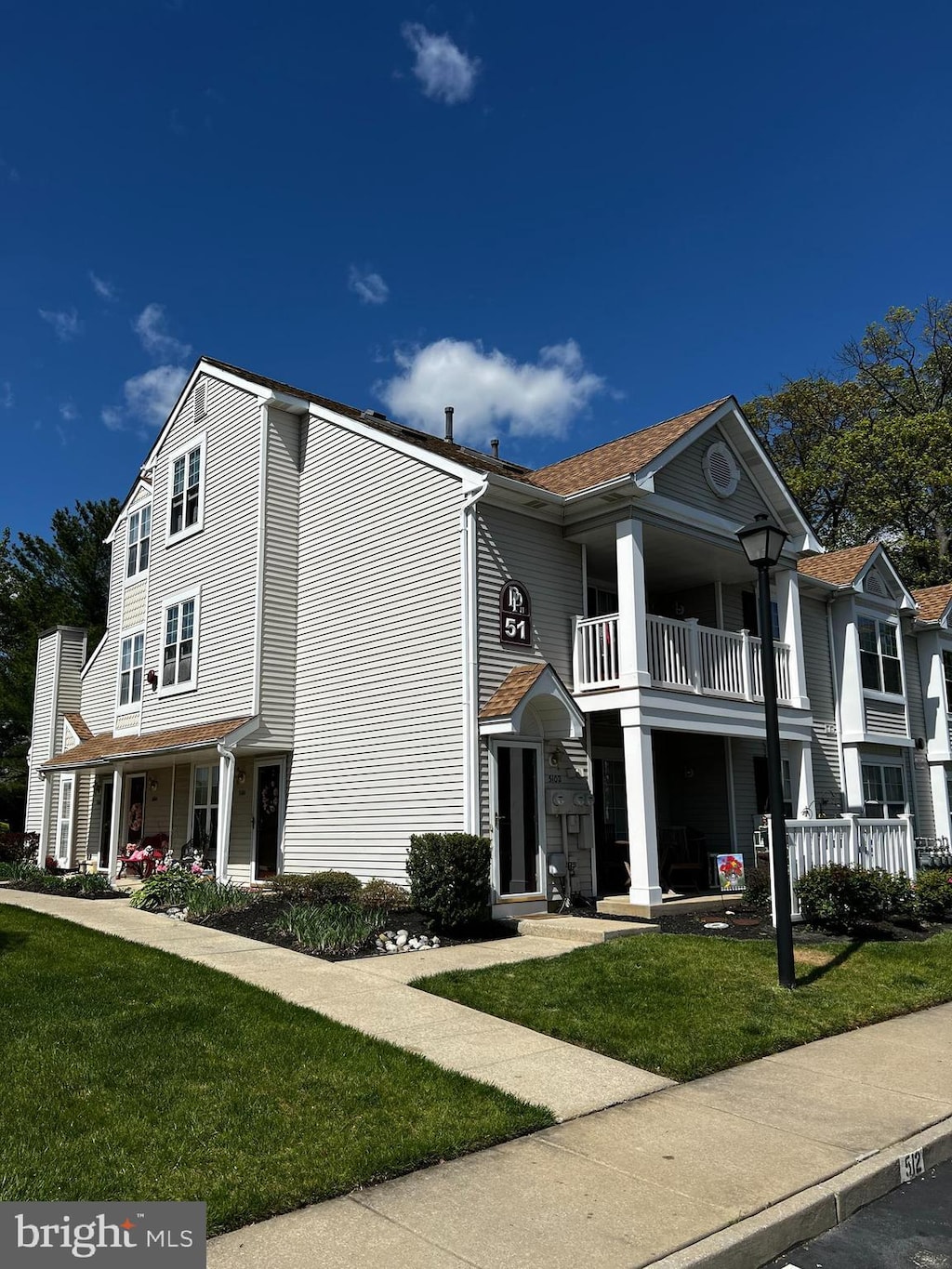 view of front of property featuring a porch, a balcony, and a front yard