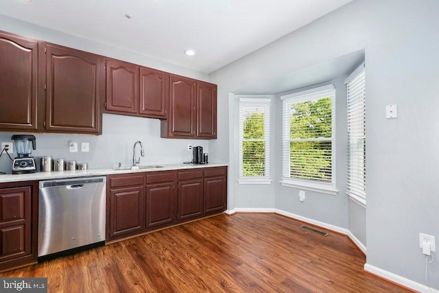 kitchen featuring a sink, dark wood-type flooring, visible vents, light countertops, and stainless steel dishwasher