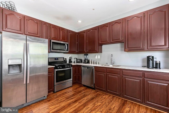 kitchen with a sink, stainless steel appliances, light countertops, and recessed lighting