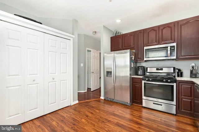kitchen with dark brown cabinets, stainless steel appliances, dark wood-type flooring, light countertops, and recessed lighting