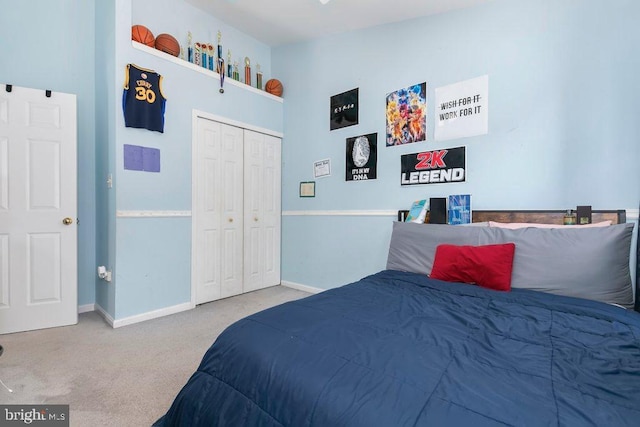 carpeted bedroom with baseboards and a closet