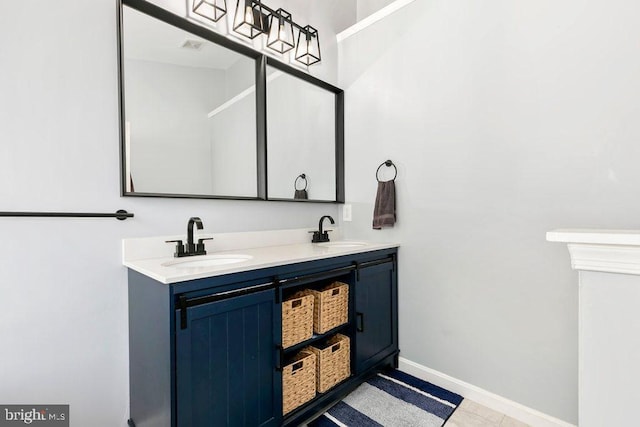 bathroom featuring double vanity, baseboards, and a sink