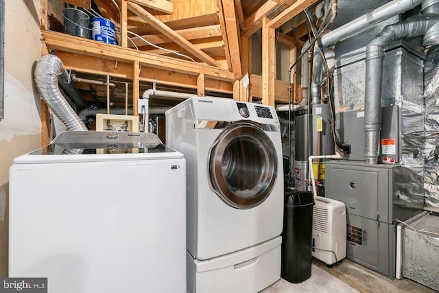 washroom with washing machine and dryer, laundry area, heating unit, and water heater