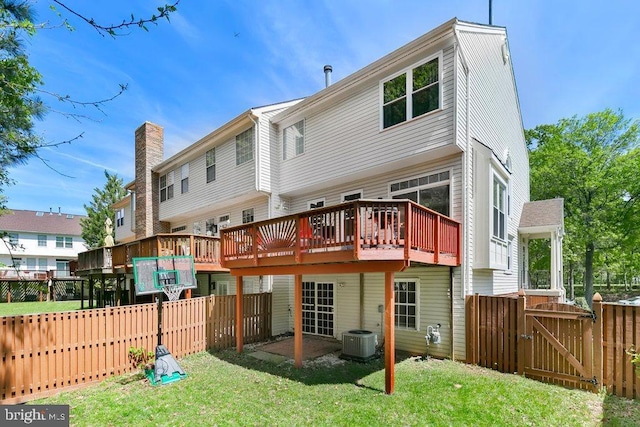 rear view of property with central AC unit, a wooden deck, a fenced backyard, and a gate