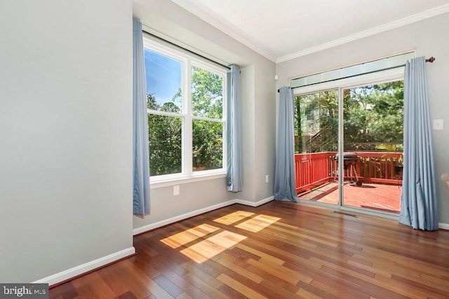 spare room featuring crown molding, visible vents, baseboards, and hardwood / wood-style floors