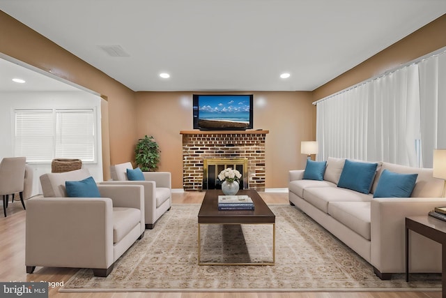living room featuring wood finished floors, a fireplace, and recessed lighting