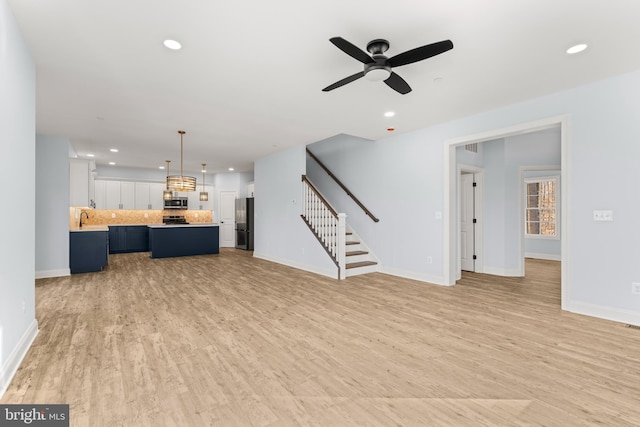 W Main Blvd, Lutherville Timonium, MD 21093 - unfurnished living room with recessed lighting, stairway, and light wood-style floors