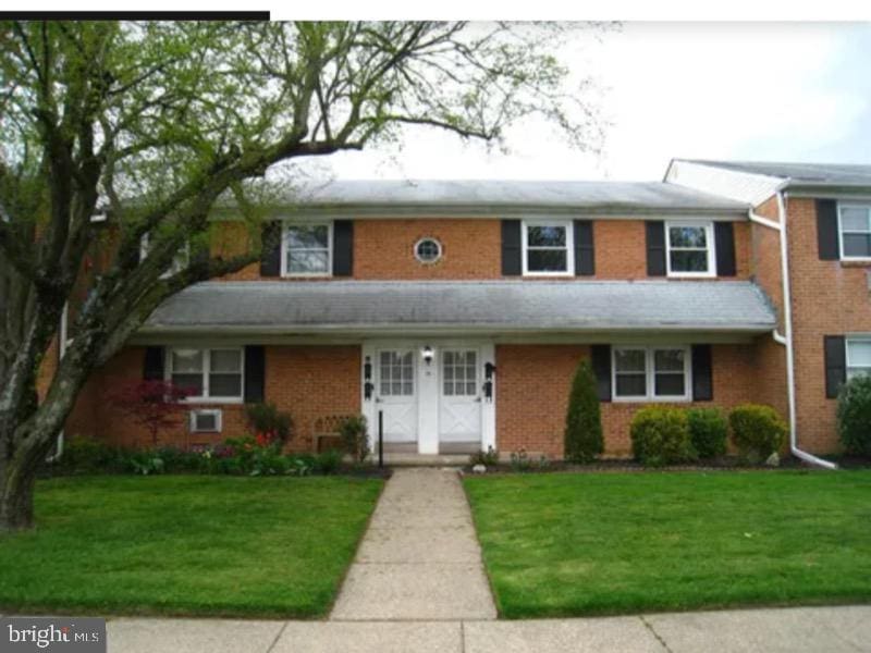 view of front of house with brick siding and a front lawn