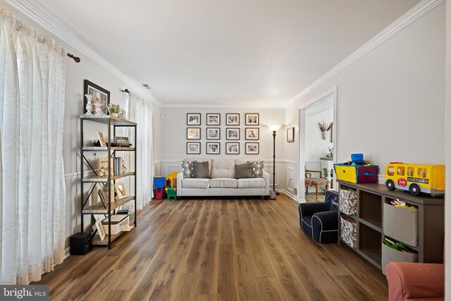 living area with crown molding, wainscoting, and wood finished floors