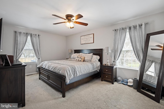 bedroom featuring baseboards, ceiling fan, and light colored carpet