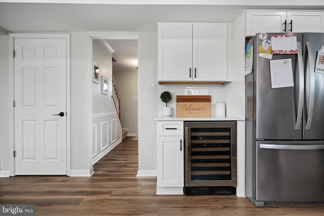 bar with backsplash, crown molding, a dry bar, freestanding refrigerator, and beverage cooler