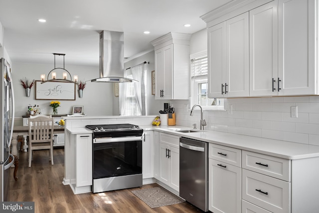 kitchen featuring white cabinets, island range hood, appliances with stainless steel finishes, and a sink