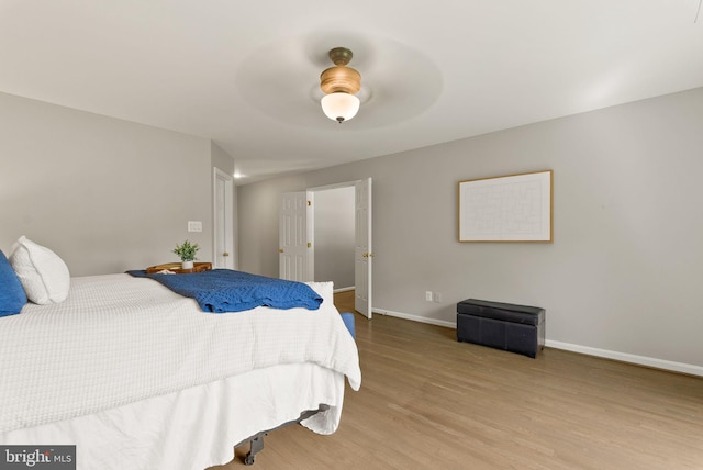 bedroom with baseboards, ceiling fan, and wood finished floors