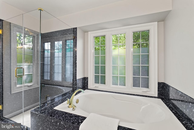 full bath with plenty of natural light and a garden tub