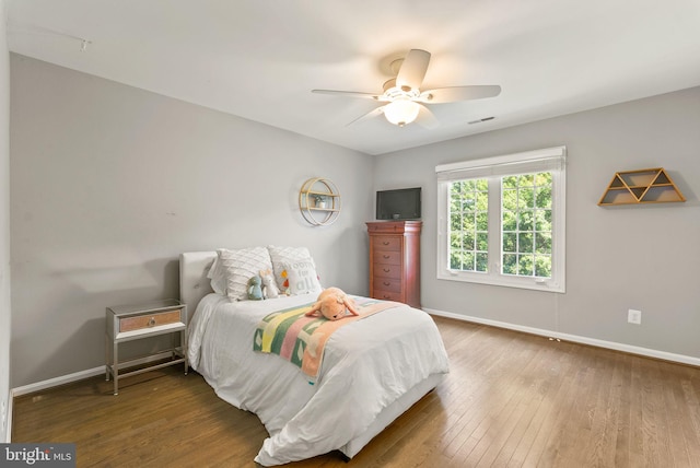 bedroom featuring baseboards, wood finished floors, and visible vents