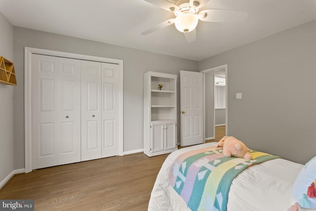 bedroom with baseboards, a ceiling fan, a closet, and wood finished floors