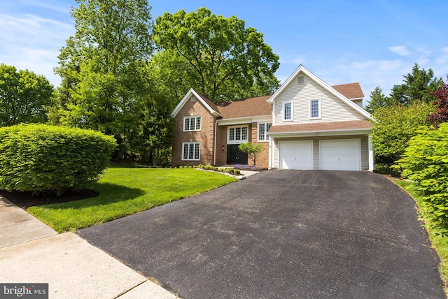 tri-level home featuring a garage, a shingled roof, a front yard, and aphalt driveway