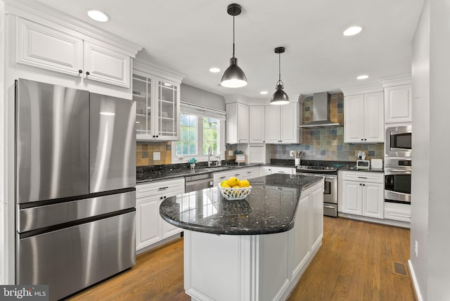 kitchen featuring white cabinets, stainless steel appliances, and wall chimney exhaust hood