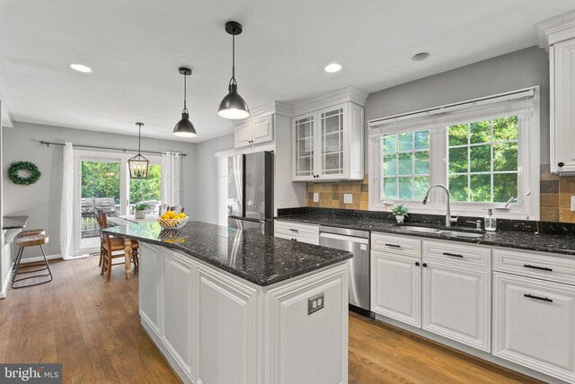 9100 Wood Spice Ln, Lorton, VA 22079 - kitchen with a kitchen island, glass insert cabinets, white cabinets, a sink, and stainless steel appliances