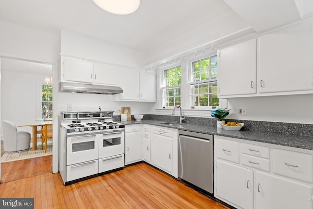 kitchen with double oven range, stainless steel dishwasher, a sink, white cabinets, and under cabinet range hood