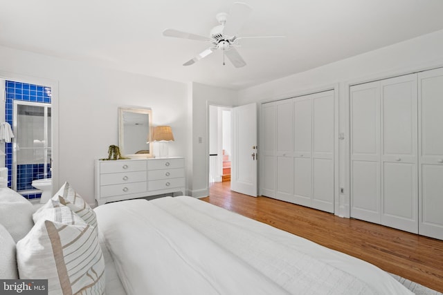 bedroom with multiple closets, ceiling fan, wood finished floors, and connected bathroom