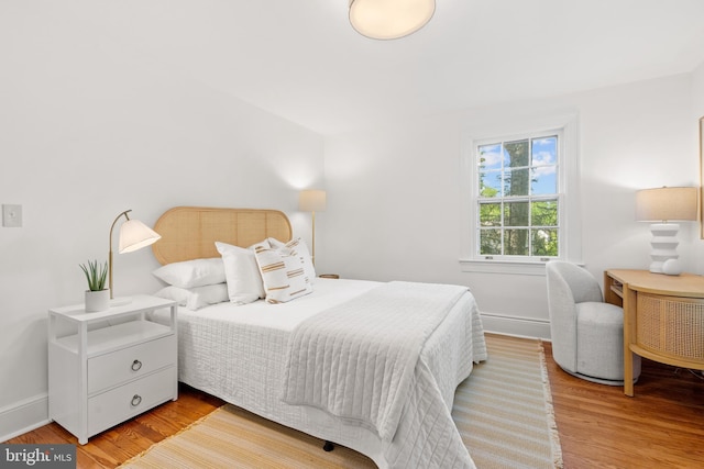 bedroom featuring baseboards and wood finished floors