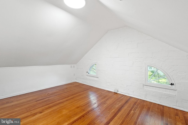 bonus room with baseboards, vaulted ceiling, and hardwood / wood-style flooring