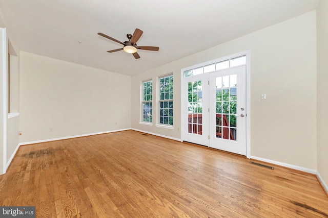 spare room featuring light wood-style floors, ceiling fan, and baseboards