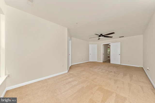 unfurnished room featuring light colored carpet, baseboards, and a ceiling fan