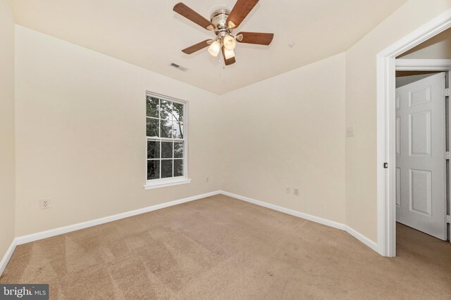 unfurnished room with light colored carpet, baseboards, and a ceiling fan