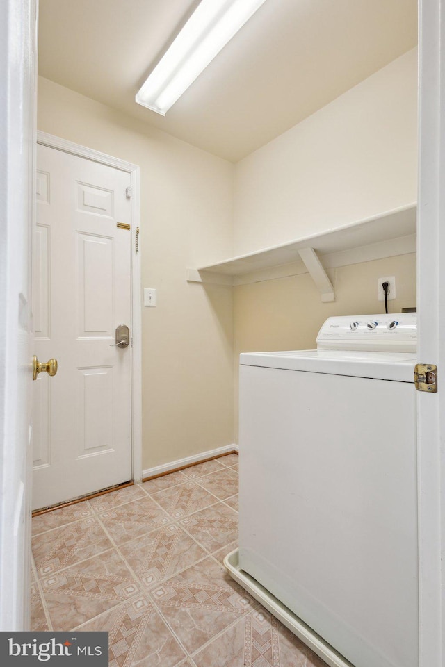 laundry area featuring washer / dryer, baseboards, laundry area, and light tile patterned flooring