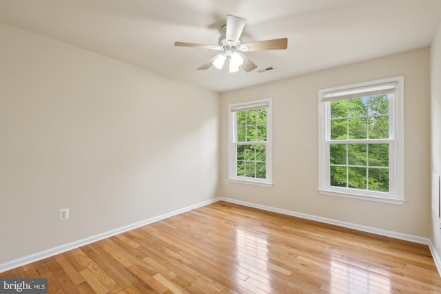 spare room with baseboards, a ceiling fan, and light wood-style flooring