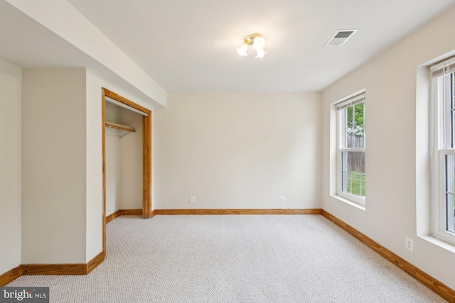 unfurnished bedroom featuring baseboards, visible vents, and carpet